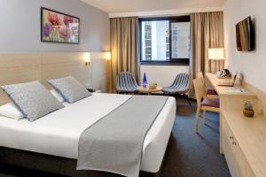 卢尔德帕多瓦酒店的配有一张床和一张书桌的酒店客房