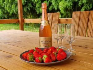 LarzacMoulin de l'Hoste的桌子上放着一瓶香槟和一盘草莓
