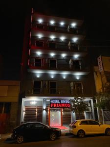 雅典Priamos Hotel Erato的两辆汽车晚上停在大楼前