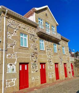 曼泰加什Casa de São Marcos的一座石头建筑,设有红色的门和阳台