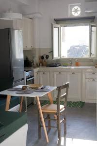 SkaládhosCasa Di Volto的厨房配有桌椅和冰箱。