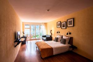 勒森蒂埃罗切利贝尔维酒店的一间卧室设有一张床和一间客厅。