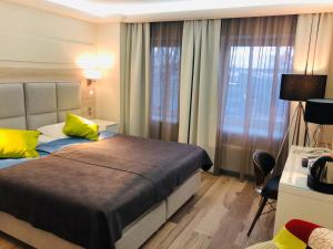 利耶帕亚Amrita Hotel的一间卧室配有一张带黄色枕头的大床