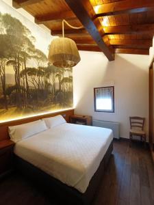 乌尔涅塔欧阿诺姆酒店的卧室配有一张床,墙上挂有绘画作品