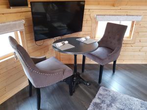 因弗内斯Unique luxury cabin 2的一张桌子和两把椅子,以及客房内的一台电视机