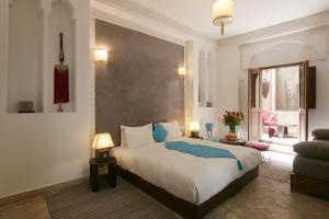 马拉喀什帕查瓦娜庭院旅馆的一间卧室设有一张大床和一个窗户。