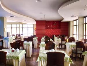 帕尔马斯基拉索斯旅馆的用餐室配有桌椅和白色桌布