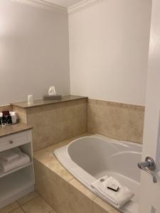 皮克顿华林豪斯酒店的浴室配有带毛巾和水槽的浴缸。