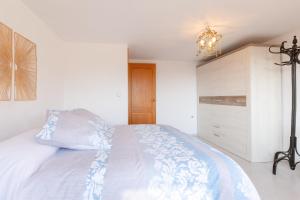 SellaCasa Marcelino y Pepa Rosa的卧室配有一张带吊灯的大型白色床。