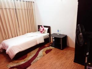 加德满都Serene B&B Kathmandu的一间卧室配有一张床、一张桌子和一个窗户。