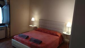 法布里亚诺Il Borghetto Medievale suite的一间卧室配有一张红色的床,上面有两盏灯