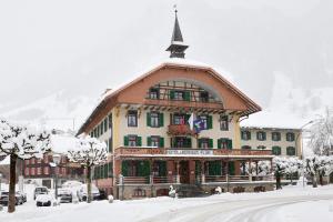 弗拉里FLÜHLI Hotel Kurhaus的一座大建筑,有屋顶在雪中