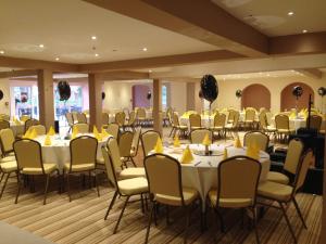 曼斯利皇家酒店的一间摆放着桌椅和黄色餐巾的房间