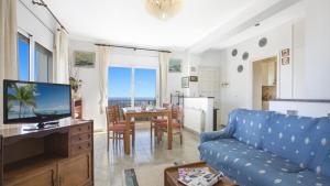 Puigventos2Tere - Lloret de Mar的一间带蓝色沙发的客厅和一间用餐室