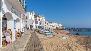 卡莱利亚德帕拉弗鲁赫尔1Solive - Calella de Palafrugell的沙滩上拥有白色建筑和沙滩上的居民