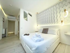 科莫Mariarosa Suites的卧室配有白色床和毛巾
