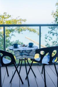 尤斯托尼莫斯基Ustronie Apartments z widokiem na morze 20 m do plaży的美景阳台配有一张桌子和两把椅子