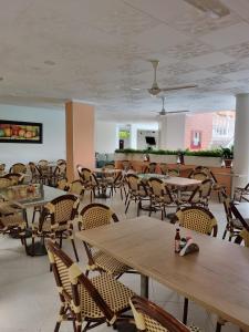 梅尔加Zahira Hotel Melgar的一间空餐厅,配有桌椅和天花板