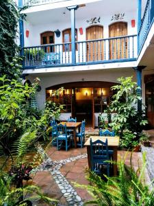 奥塔瓦洛奥塔瓦洛多纳伊斯特酒店的庭院配有蓝色的椅子和桌子