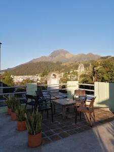 奥塔瓦洛奥塔瓦洛多纳伊斯特酒店的庭院配有桌椅,背景为山脉