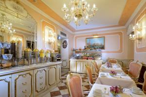 威尼斯卡纳莱托酒店的一间带2张桌子和吊灯的用餐室