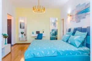 布加勒斯特New Studio Carturesti - City Center的蓝色的卧室配有蓝色的床和吊灯