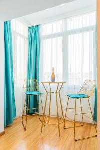 布加勒斯特New Studio Carturesti - City Center的一张桌子和两把椅子,房间带蓝色窗帘