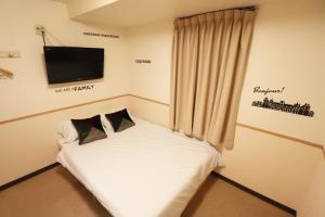 东京Hotel Yuyukan - Vacation STAY 10008v的墙上配有电视的一个小床