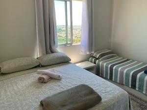 蓬塔格罗萨Sunset的一间小卧室,配有两张床和窗户