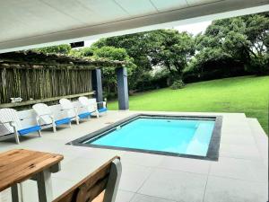 谢普斯敦港Anchors Rest的庭院内的游泳池配有桌椅