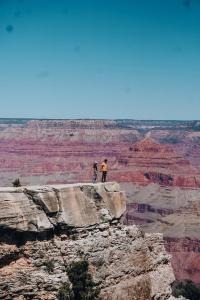 瓦莱Wander Camp Grand Canyon的两个站在大峡谷边缘的人