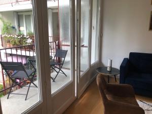 枫丹白露75 m2 # logia & parking gratuit # BESTOFBLO 4 #的带沙发和椅子的客厅以及阳台。