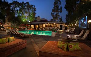 洛杉矶加兰酒店的一个带躺椅的游泳池以及一间餐厅