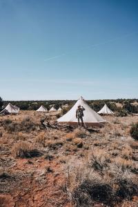瓦莱Wander Camp Grand Canyon的站在田野帐篷前的人