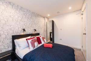 利物浦The Blossoms Studio Apartments的一间卧室配有红色和白色枕头的床