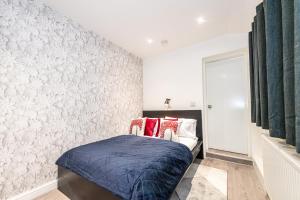利物浦The Blossoms Studio Apartments的一间卧室配有一张带红色枕头的床