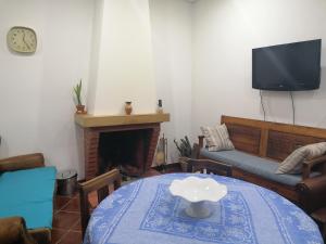 VilarinhoCasa do Bonifácio的客厅配有桌子、沙发和电视。
