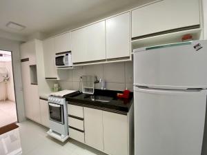 伊列乌斯Jardins de Ilhéus - Apto COMPLETO localização PRIVILEGIADA的厨房配有白色橱柜和白色冰箱。