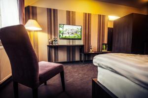 Plewiska菲加酒店的酒店客房,配有床和电视