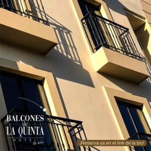 里奥阿查Balcones de la Quinta的带阳台的建筑,旁边设有标志