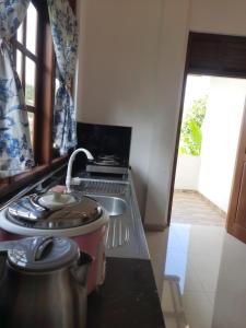 马特勒Muthuarana Villa Matara的厨房配有炉灶和台面上的锅
