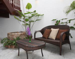 马六甲金杰弗劳尔精品酒店的一间设有椅子和桌子的房间,并种植了植物