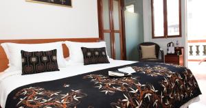马六甲金杰弗劳尔精品酒店的一间卧室配有一张带黑白毯子的床