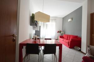 米兰森尼西奥住宅酒店的客厅配有桌子和红色沙发