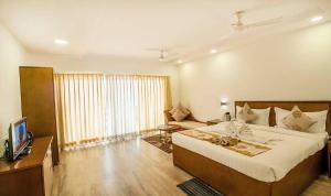 Bāgnān索娜邦拉科拉加特酒店的一间卧室配有一张大床和电视