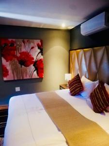 索赫燕杜Thavhani boutique hotel的卧室配有一张大床,墙上挂着红色鲜花