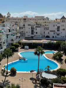 滨海罗克塔斯Apartamentos Roquetas Beach的享有大型游泳池空中美景,设有建筑