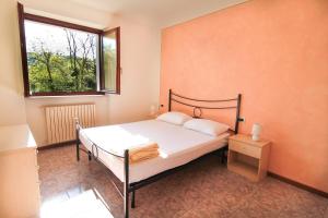 加尔达Residence Corte del Bosco的一间卧室设有一张床和一个窗口