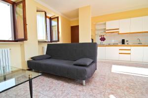 加尔达Residence Corte del Bosco的一间带黑色沙发的客厅和一间厨房