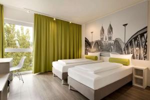 弗莱堡弗莱堡速8酒店的一间卧室设有三张床和绿帘